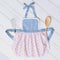 Baby and toddler apron with lace trim, flat lay with wooden spoon
