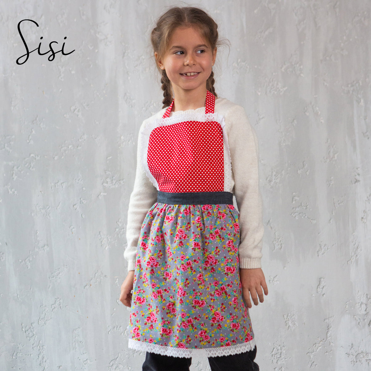 Sisi kids apron with lace trim, worn by a girl