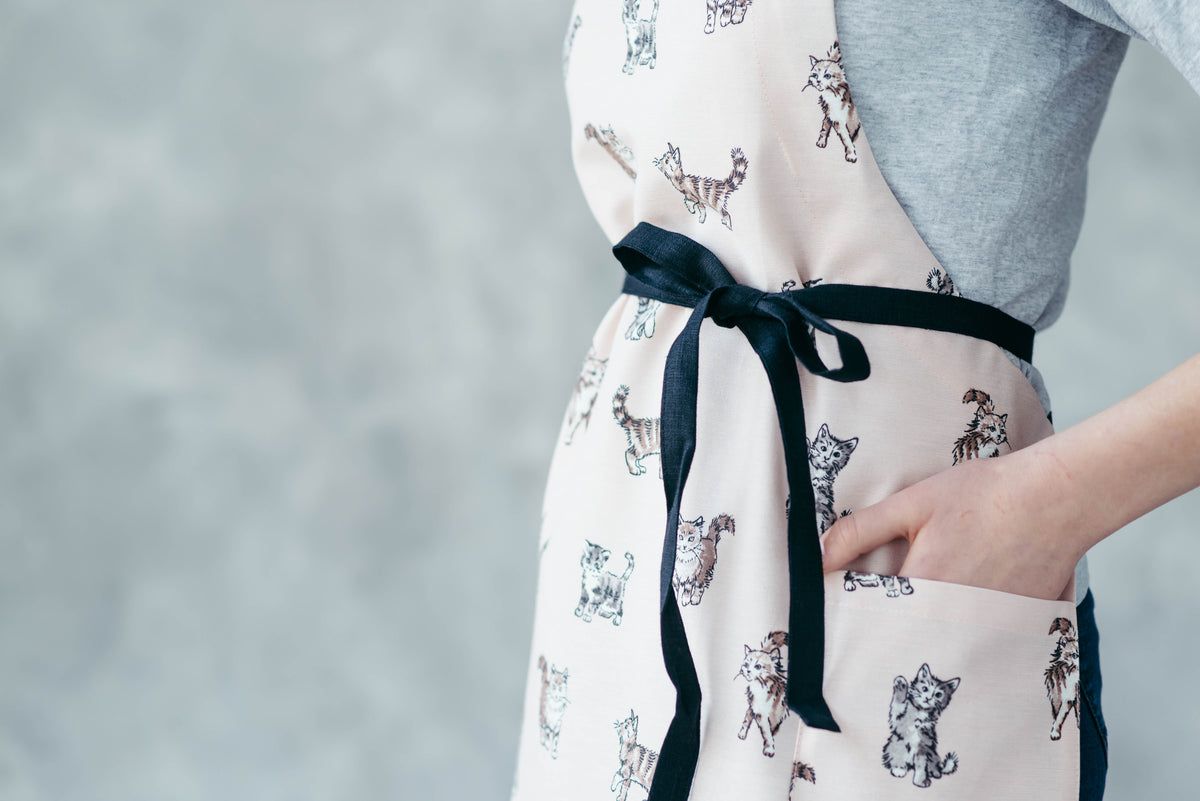 Cat print apron worn in the kitchen