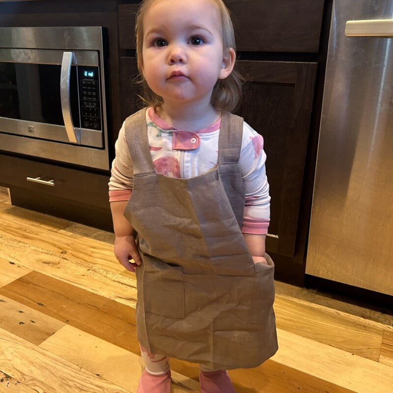 Customer photo, toddler in a linen apron in the kitchen