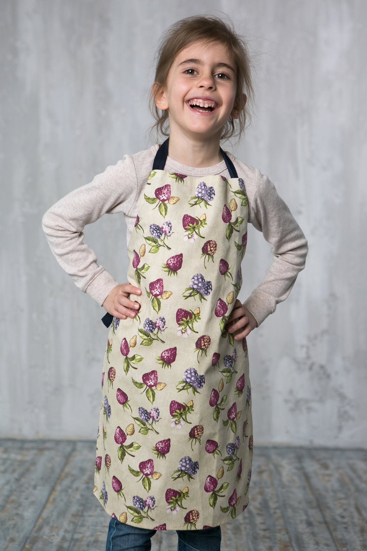 Strawberry print kids apron in beige, front view