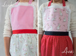 Embroidered name detail on a printed lace apron
