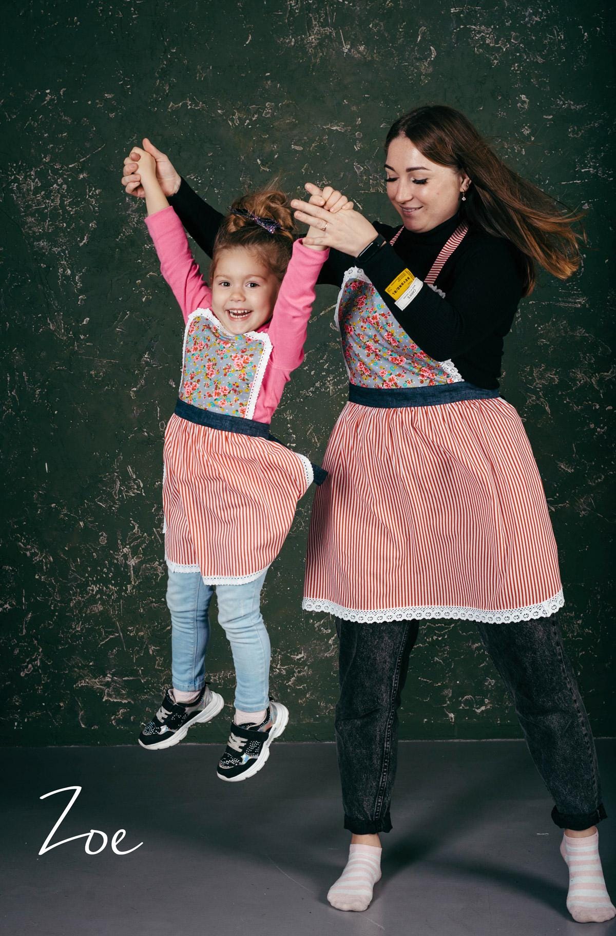 Matching lace aprons, mother and daughter styled