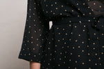 Close view of the beige polka dots on the black chiffon