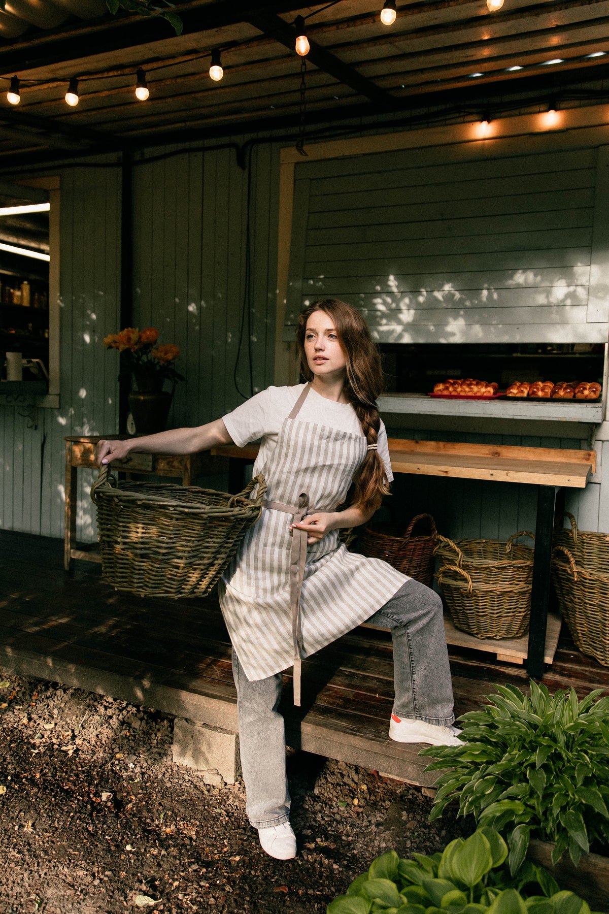 Unisex linen apron in taupe stripe, styled on model