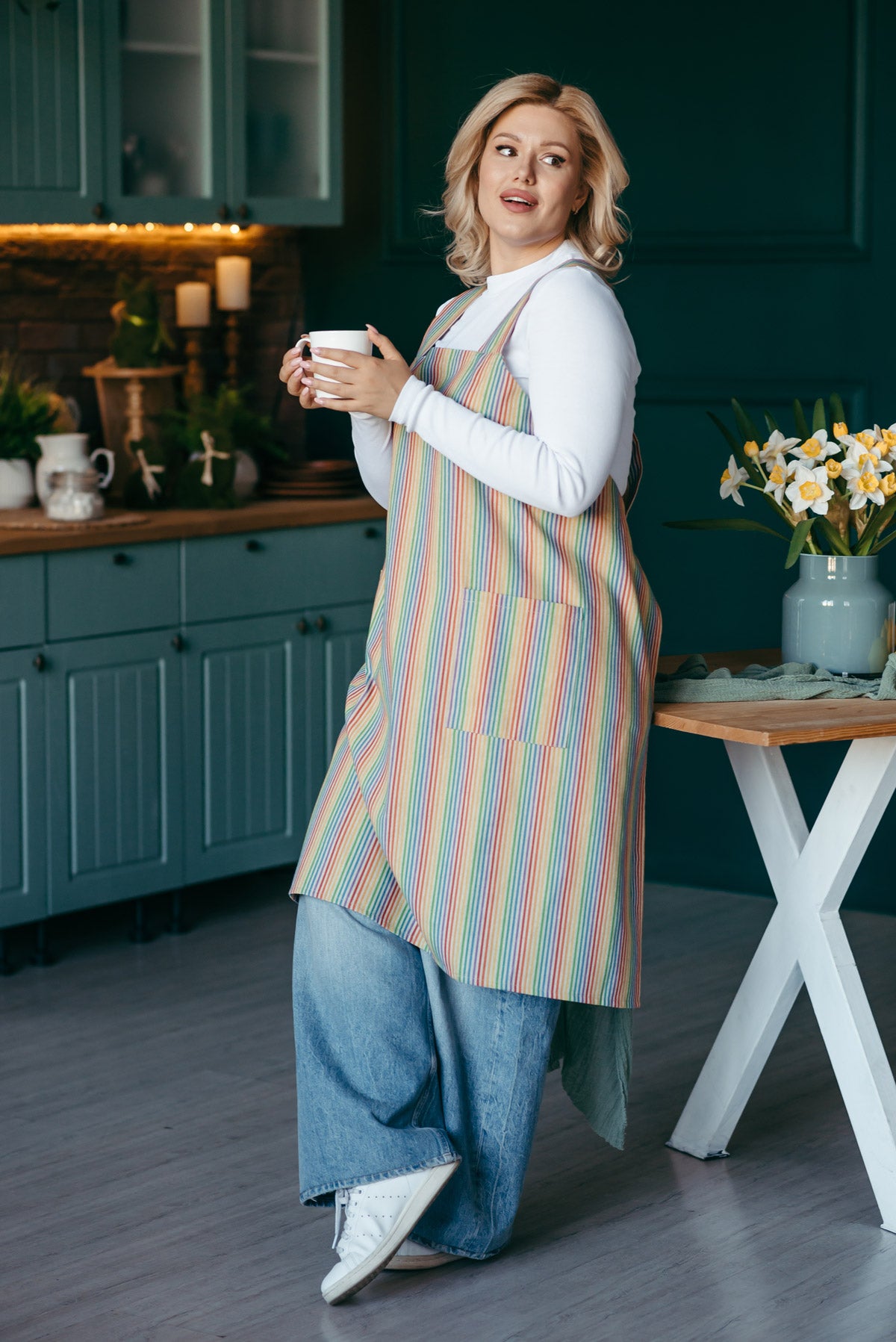 Rainbow linen pinafore apron with deep front pockets, maker wearing it