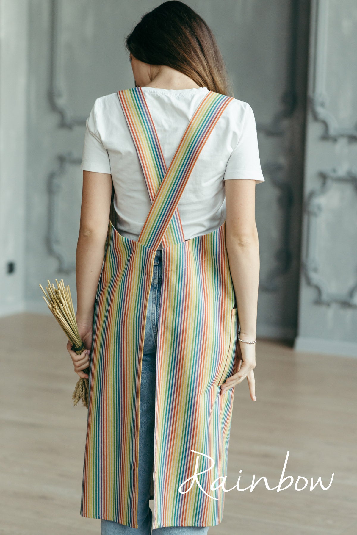 Rainbow stripe linen pinafore apron on a hanger