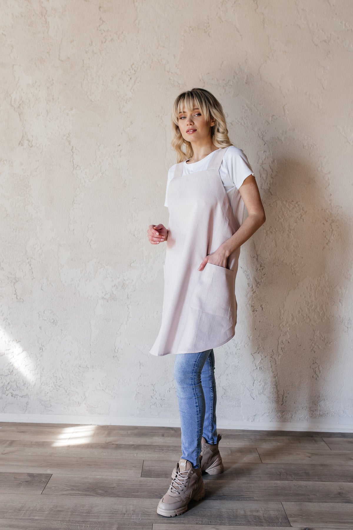 Short linen crossback apron worn by a florist
